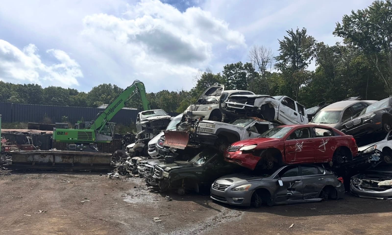 AMR's material handler working a stack of crushed cars at the yard
