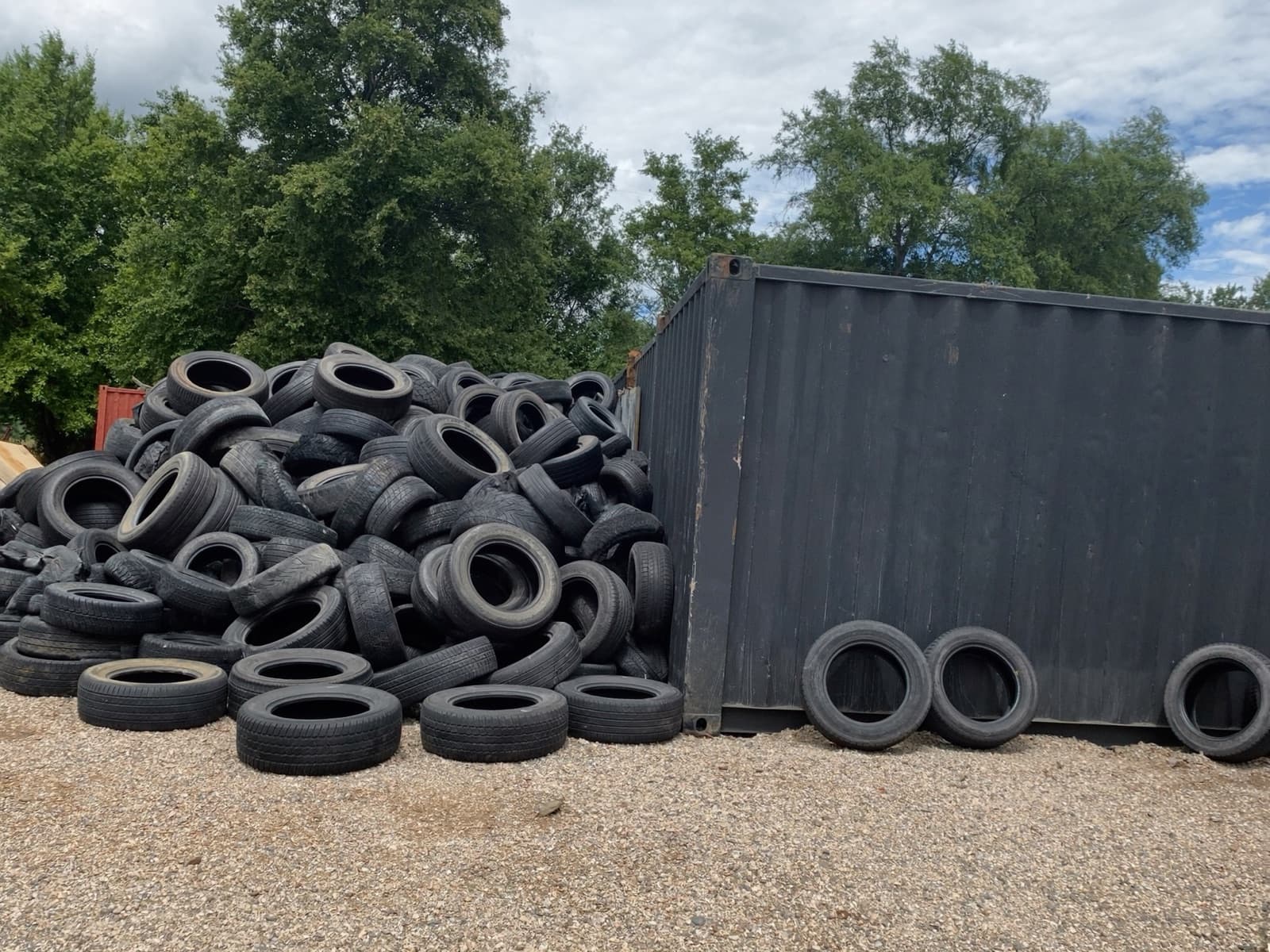 A pile of used tires beside a container at the AMR yard